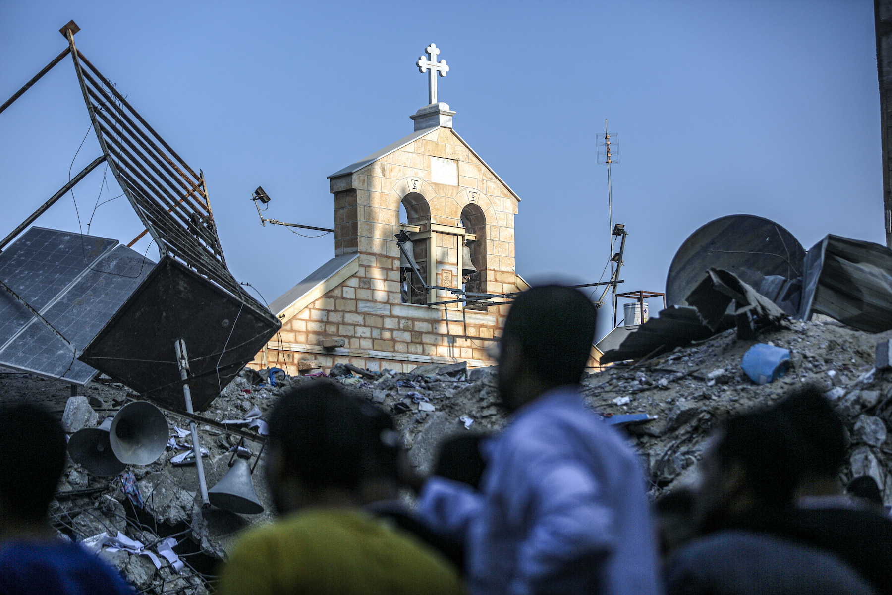 The front of a church stands amid rubble from a destroyed parish building