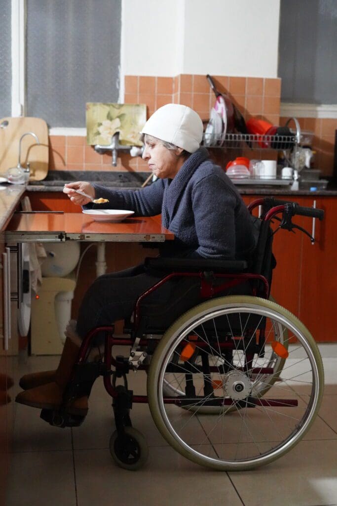 mujer en silla de ruedas se alimenta