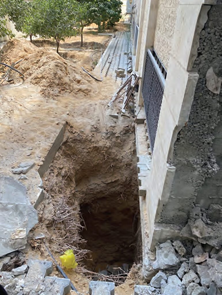 orificio al lado de pared para reparar cimientos de edificio