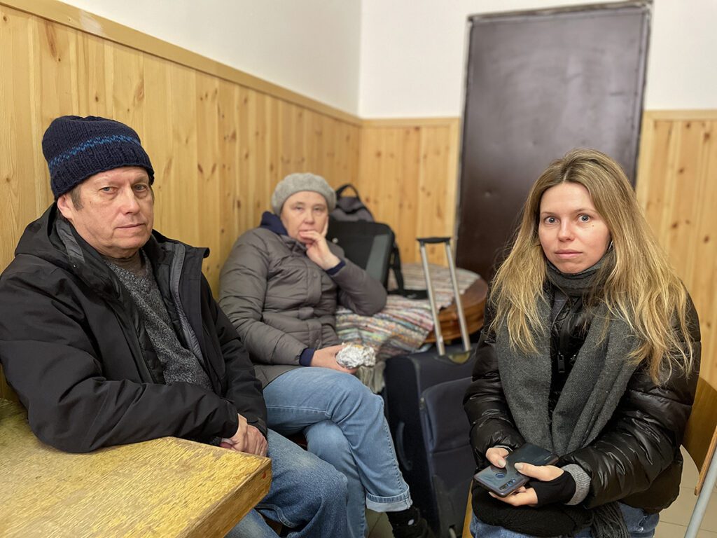 Padre, madre e hija adulta sentados en centro para refugiados de Ucrania en Hungría
