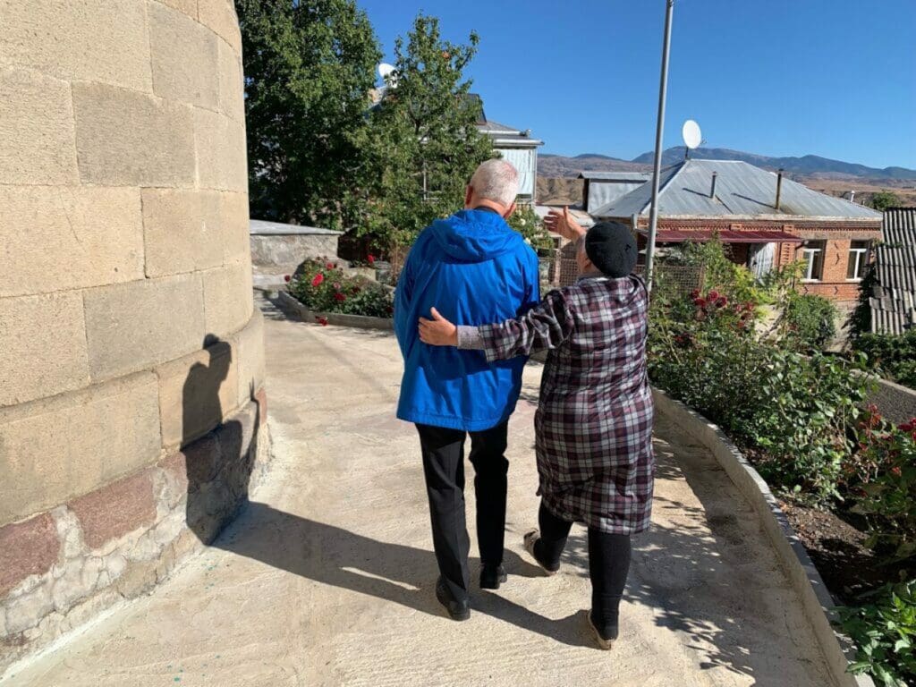 Mujer enseña a una visita los alrededores de una parroquia en Georgia.