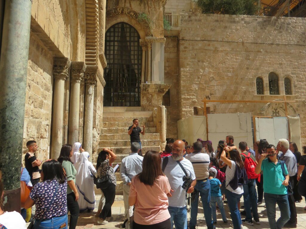 Guía turístico habla con peregrinos frente a Iglesia del Santo Sepulcro en Jerusalén.