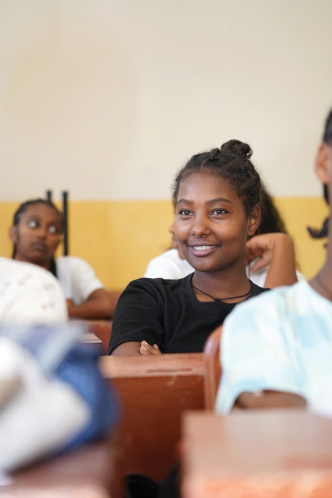Una niña sentada en un escritorio en una clase de un hogar de niñas en Etiopía.