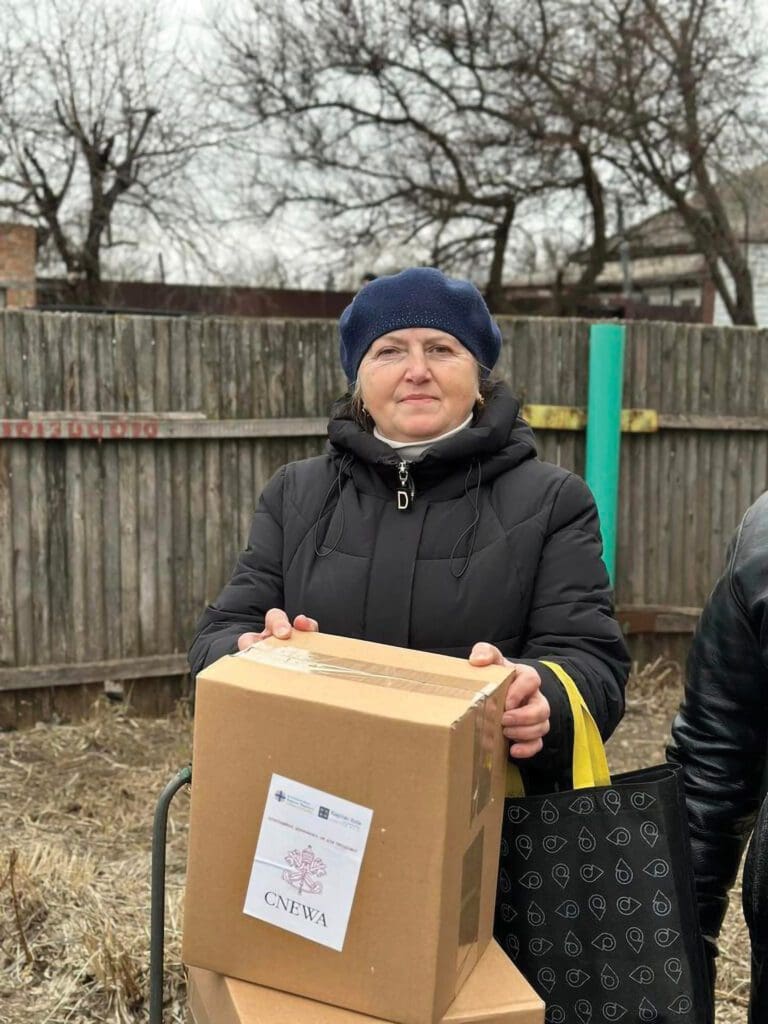 Mujer sostiene paquete de ayuda para la población de la provincia de Chernihiv.