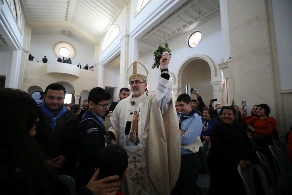 El Arzobispo Pierbattista Pizzaballa, patriarca latino de Jerusalén, rocía con agua bendita a peregrinos y visitantes del río Jordán en la Iglesia Católica del Bautismo de Cristo en Betania más allá del Jordán.