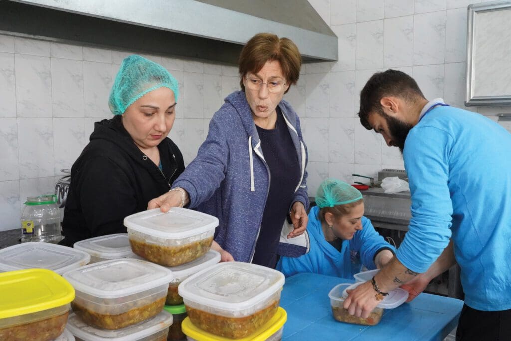 Voluntarios Maristas Azules preparan raciones de alimentos en una cocina, en Alepo.