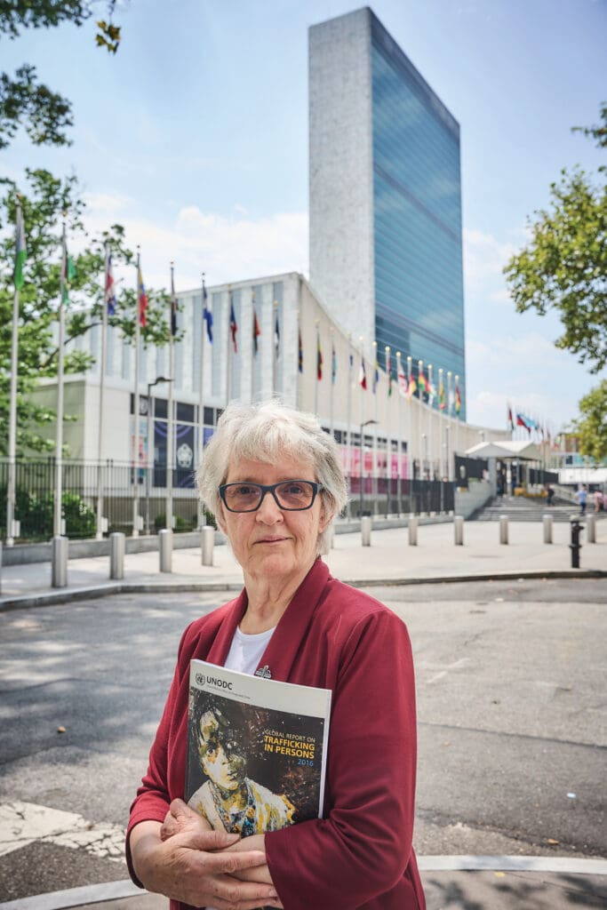 La hermana Winifred Doherty, R.G.S., frente al edificio de Naciones Unidas.