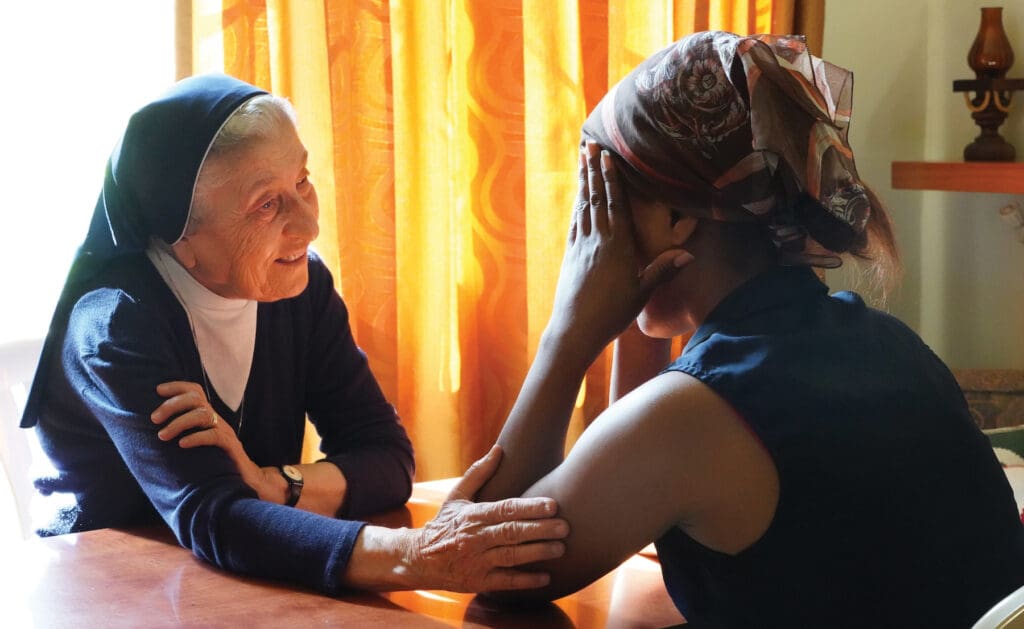 La Hermana Marie Claude Naddaf, R.G.S., consuela a una sobreviviente de trata en Beirut.