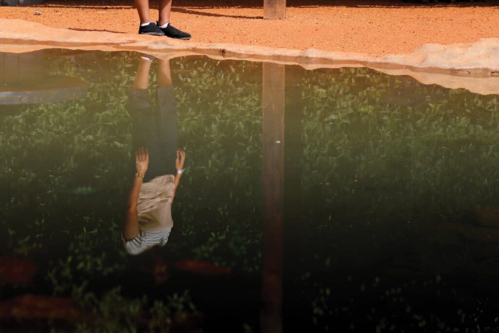 La imagen de una mujer se ve reflejada en el agua.