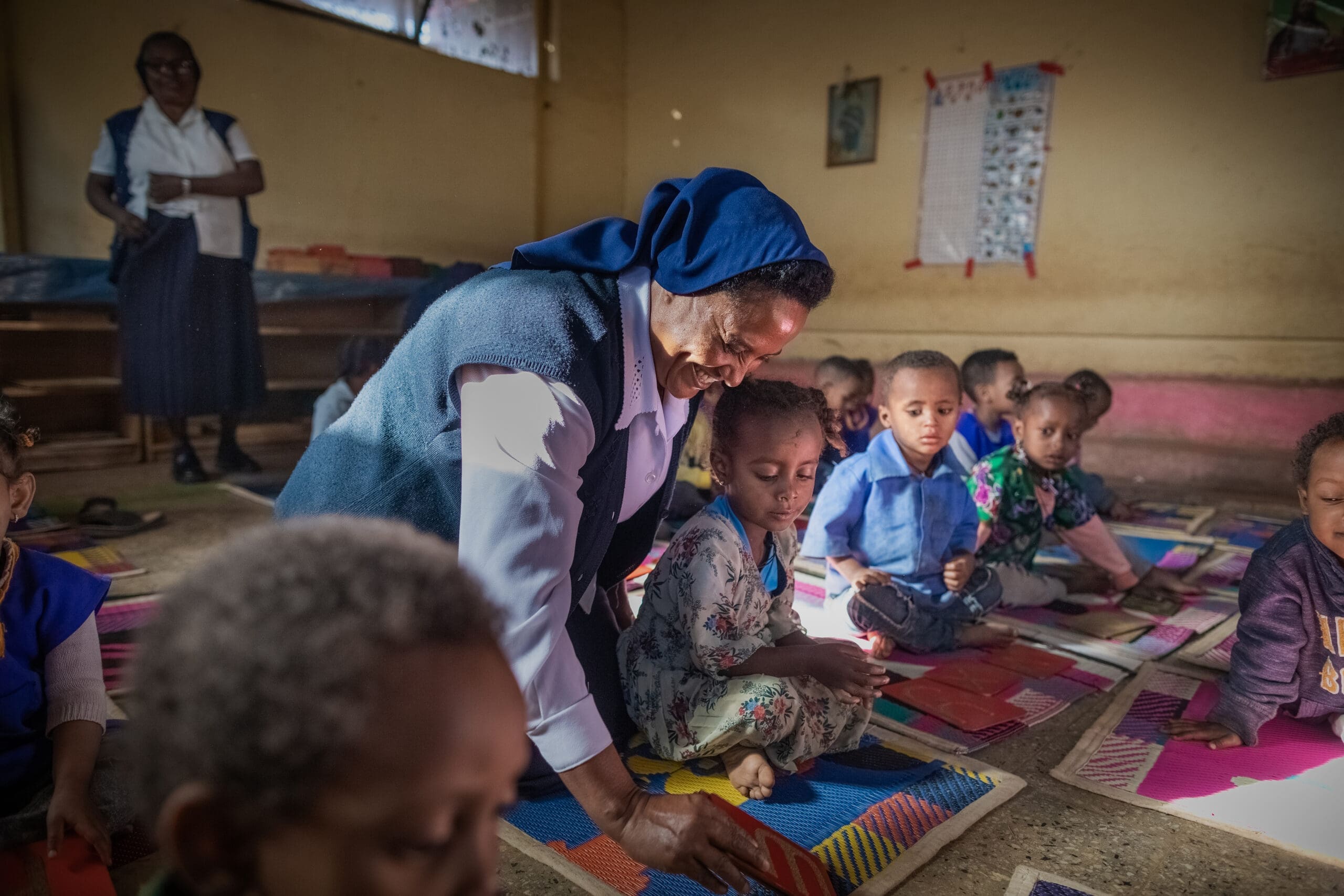 Una suora gioca insieme ai bambini in una scuola in Etiopia