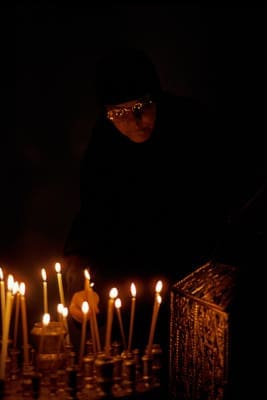 A pilgrim lights candles in Jerusalem’s Church of the Holy Sepulchre. (photo: Paul Souders)