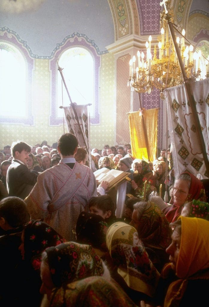 Parishioners attend a crowded liturgy in church.