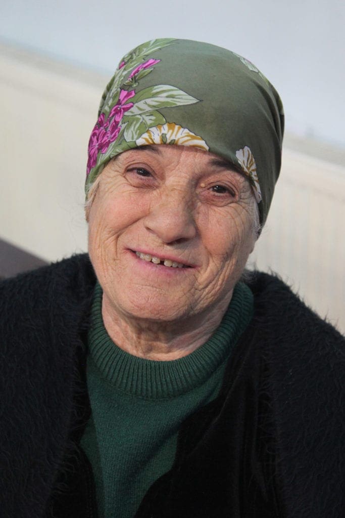a woman wearing a bandana smiles.