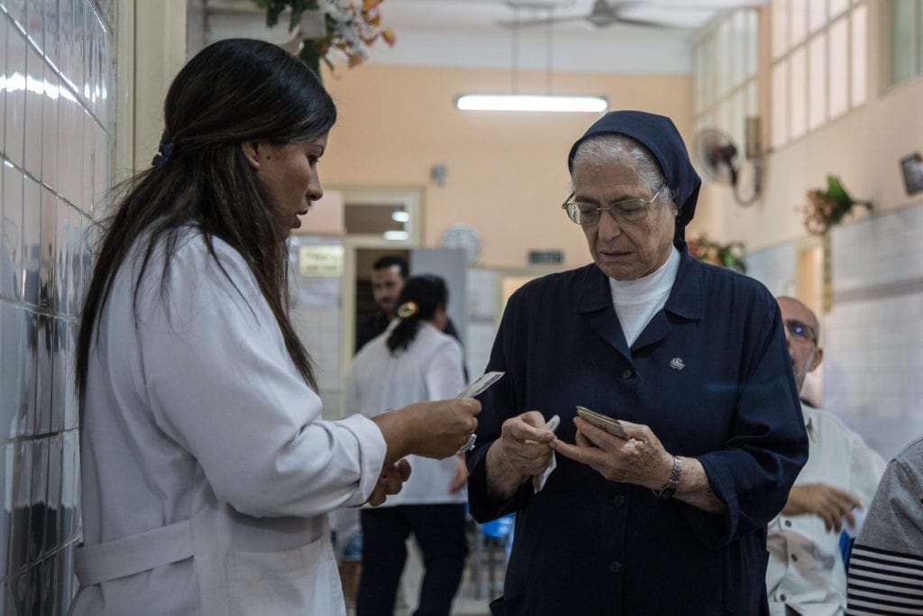 Sister simone speaks to a medical staffer at the dispensary.