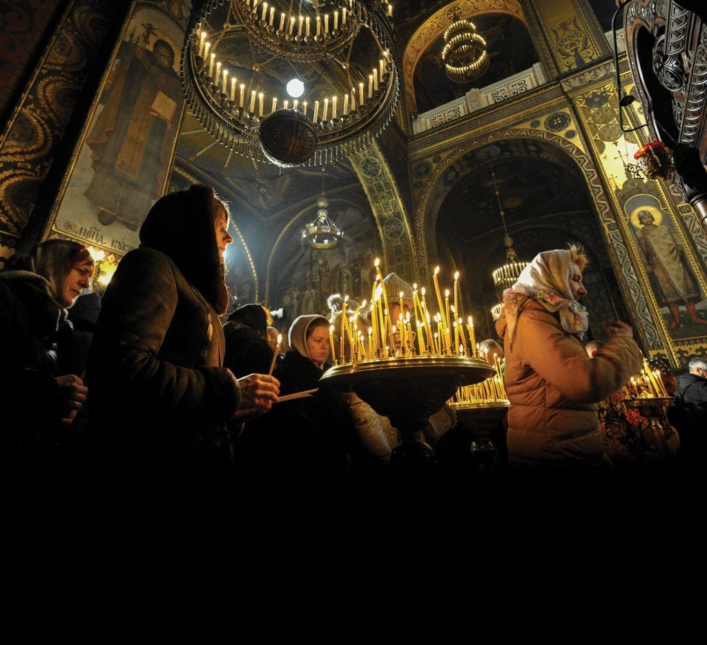 people pray in an ornate cathedral.