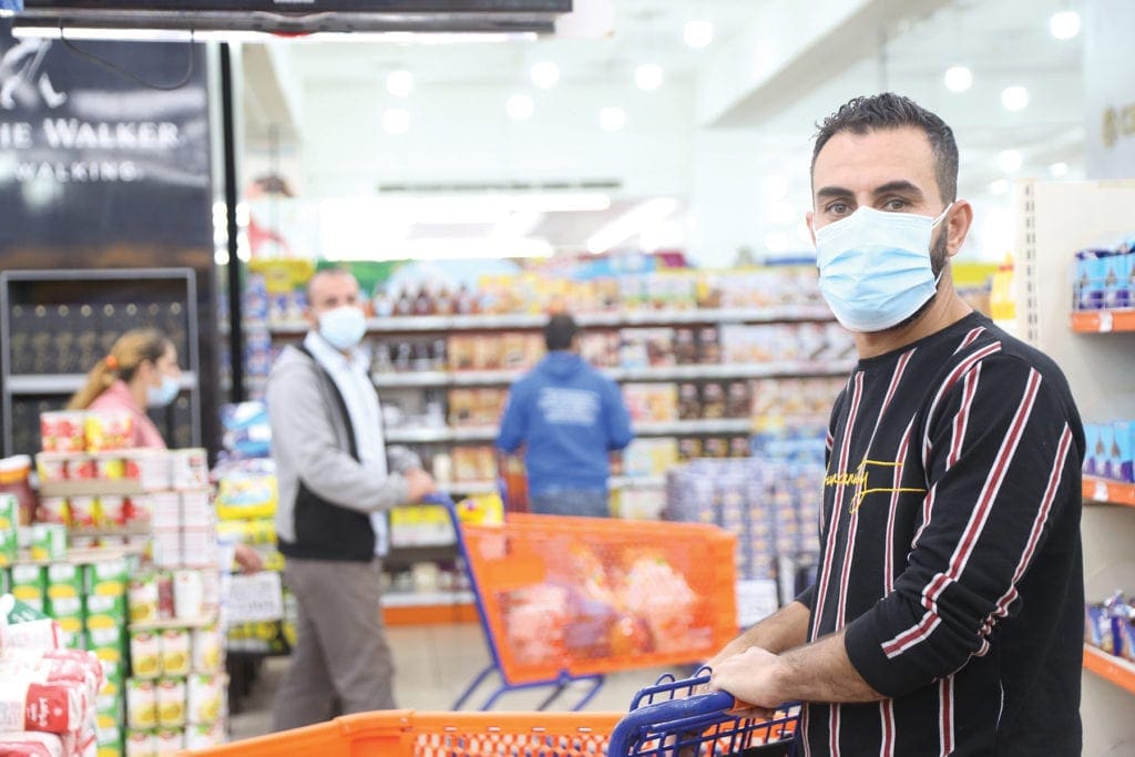 a young man pushes a shopping cart.