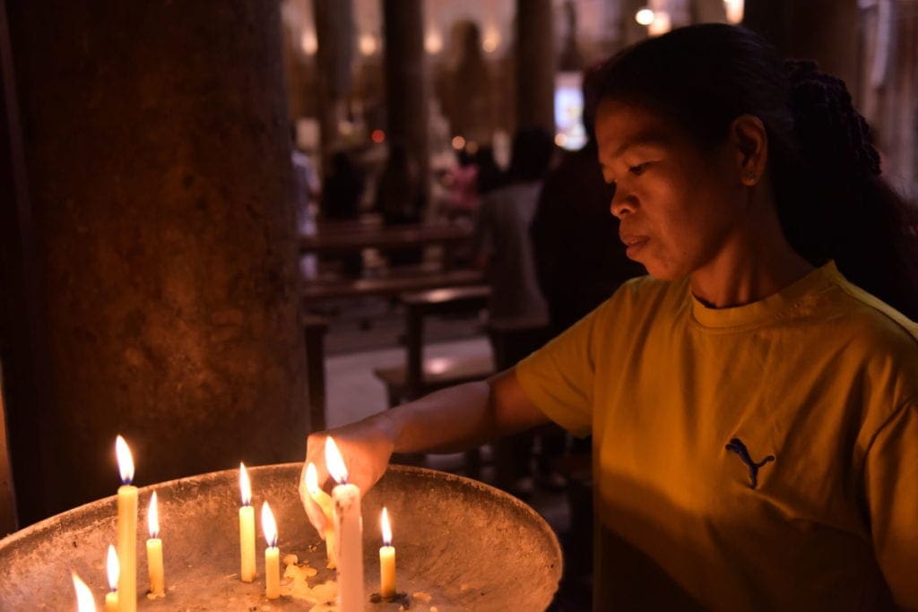 a woman lighting a candle.