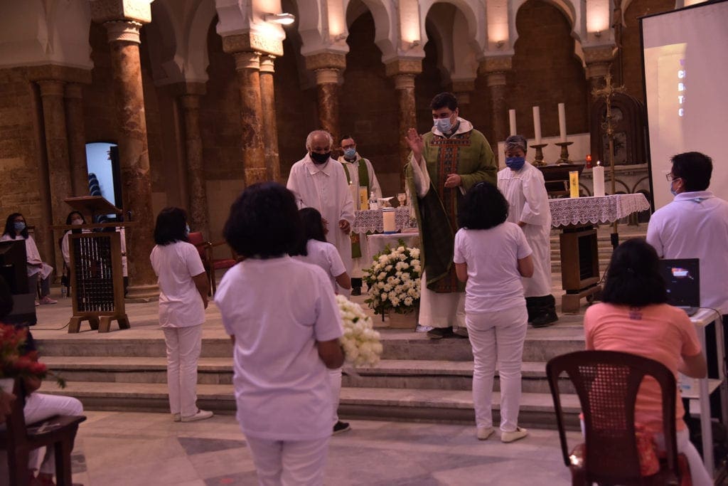 a priest and congregation pray in church.