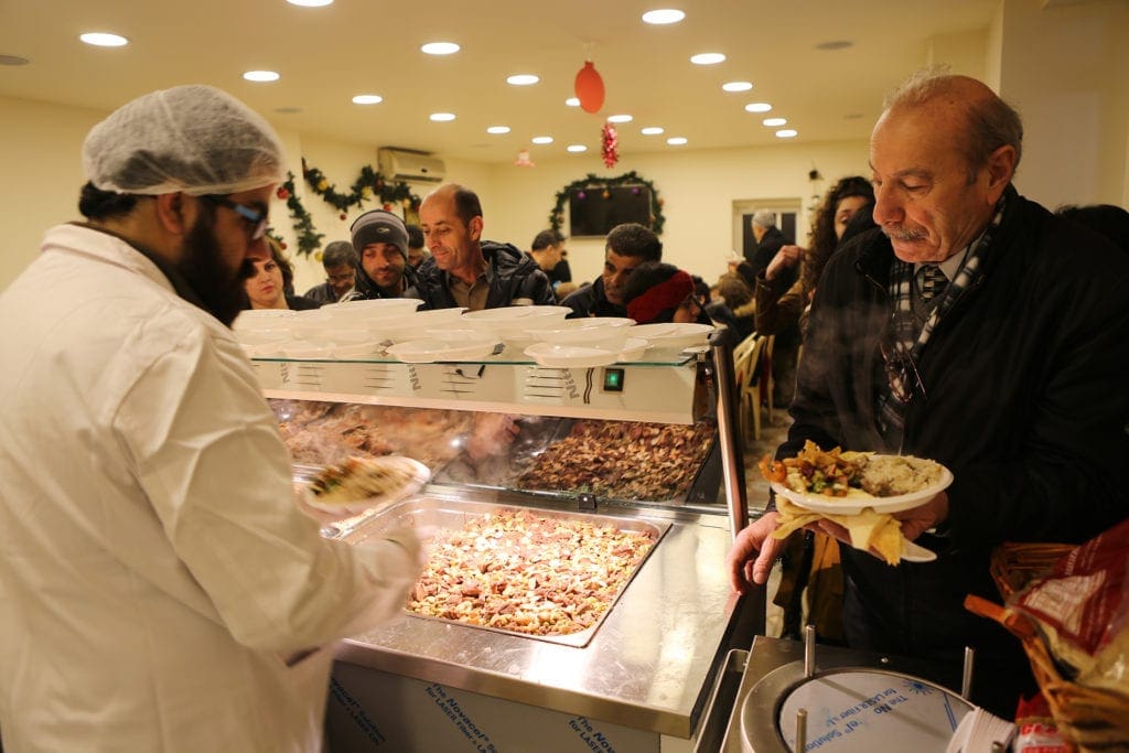 man being served a plate at a food pantry in the middle east.