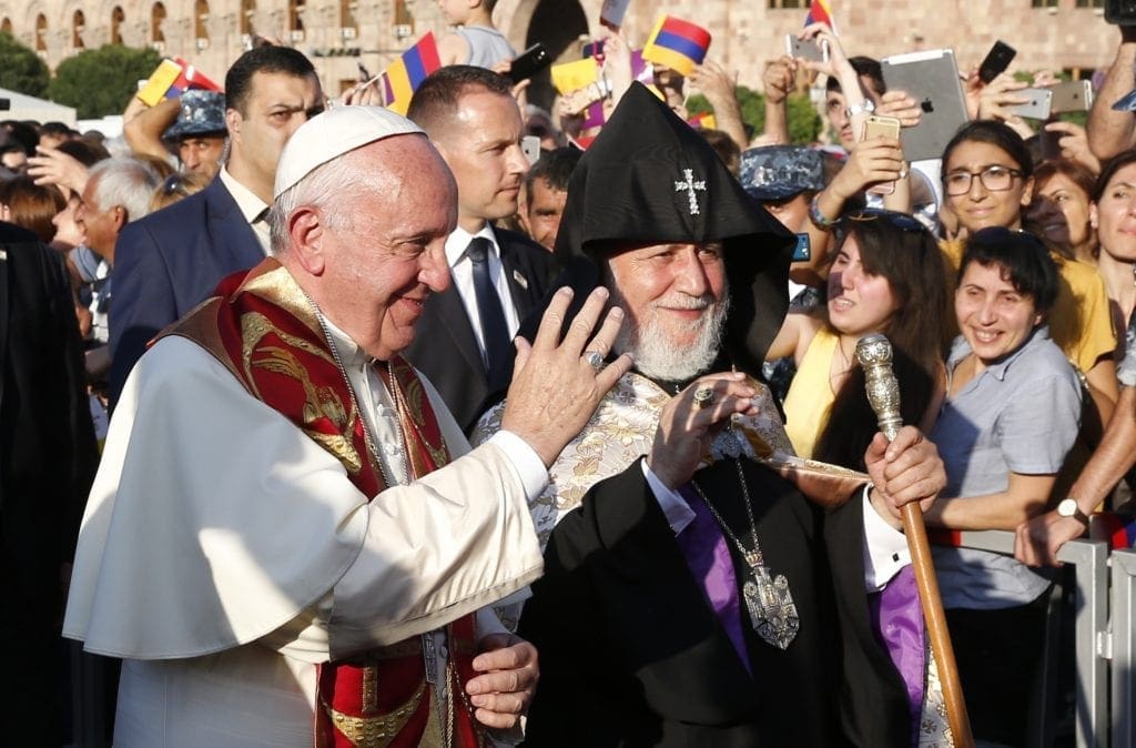 pope francis and catholicos karekin II stand together in a crowd.