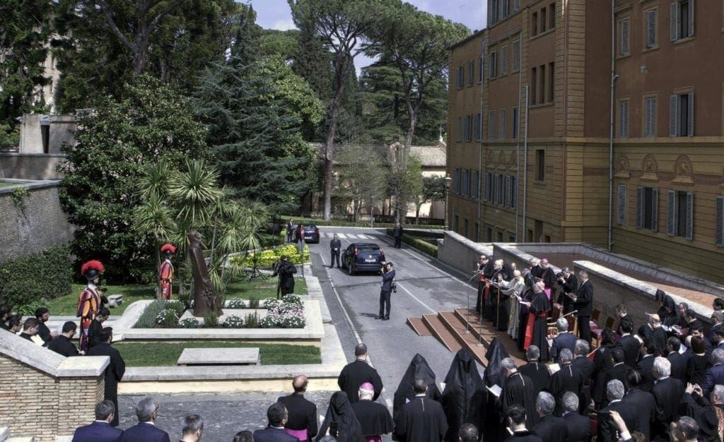 A crowd gathers for a blessing of a statue.