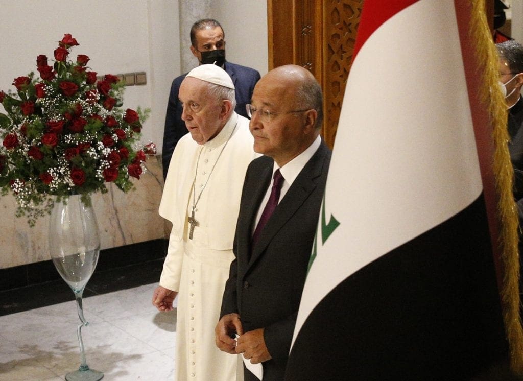 Pope Francis and Iraqi President Barham Salih arrive for a meeting in the hall of the presidential palace in Baghdad