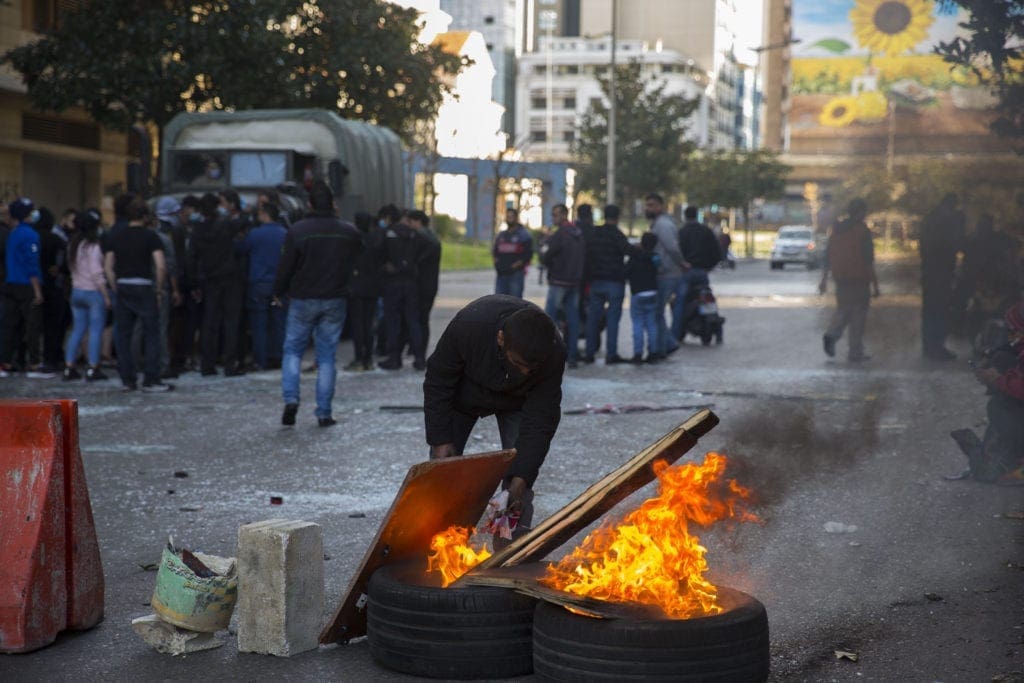 A protest tends to burning tires on a street in Beirut