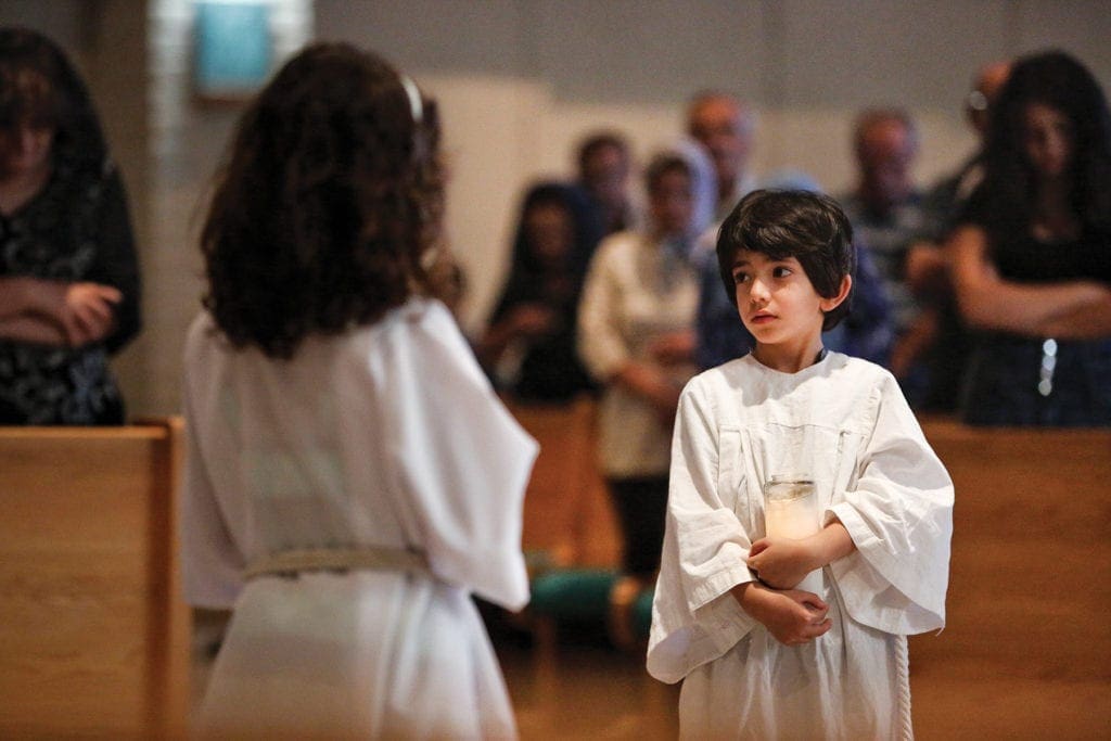 altar servers carry candles.
