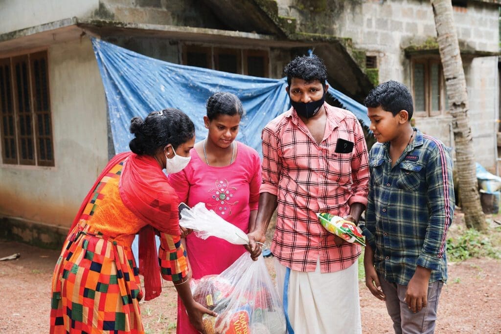 four young men and women pull packages of pandemic supplies out of a larger bag.