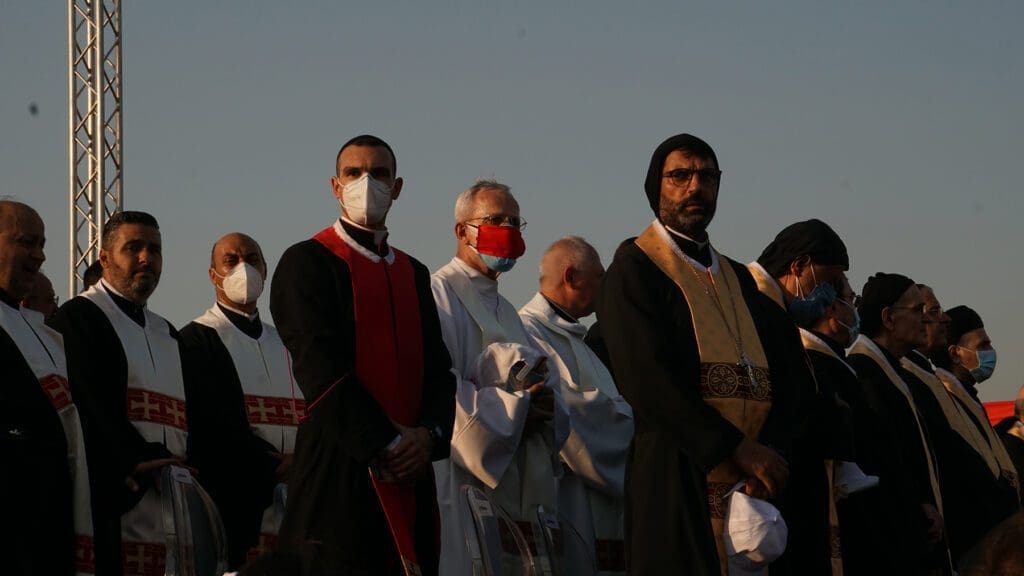 priests stand outside to pray at a memorial service in Lebanon.