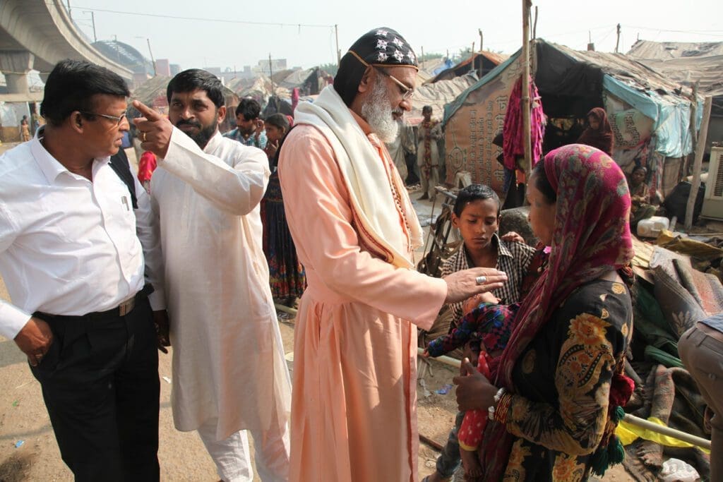 Bishop Mar Barnabas blesses a woman in a poor community outside of Delhi.