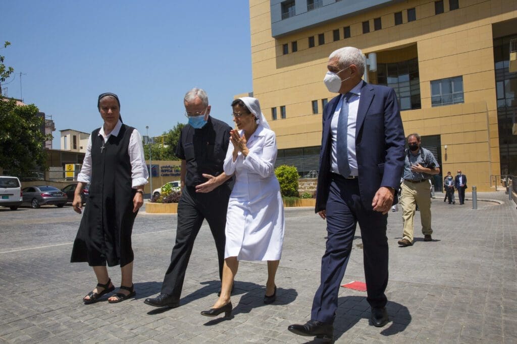four people, including CNEWA president and two nuns, walk outside and discuss emergency response to lebanon blast.