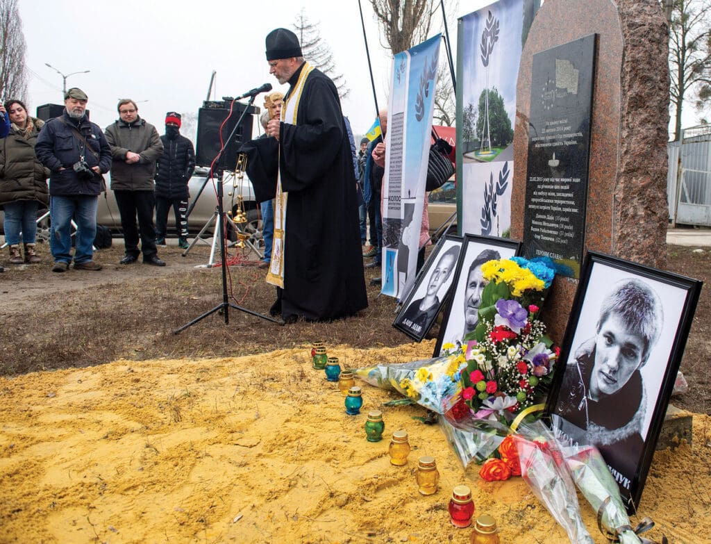 An Orthodox priest leads a memorial service in Kharkiv, eastern Ukraine, on 22 February 2022, for those killed seven years earlier by a landmine that had been planted on the route of a procession marking the anniversary of the Maidan revolution. About two days later, Kharkiv was shelled.