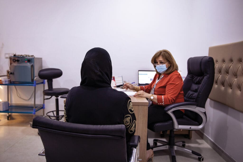 Dr. Muna Ghanim Majeed Shaya listens to a patient at the Mar Narsai health dispensary.