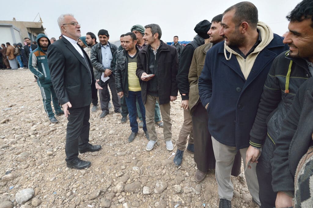 Archimandrite Emanuel Youkhana spends much of his time in the field. Here, he is with displaced people outside Mosul, Iraq, in January 2017