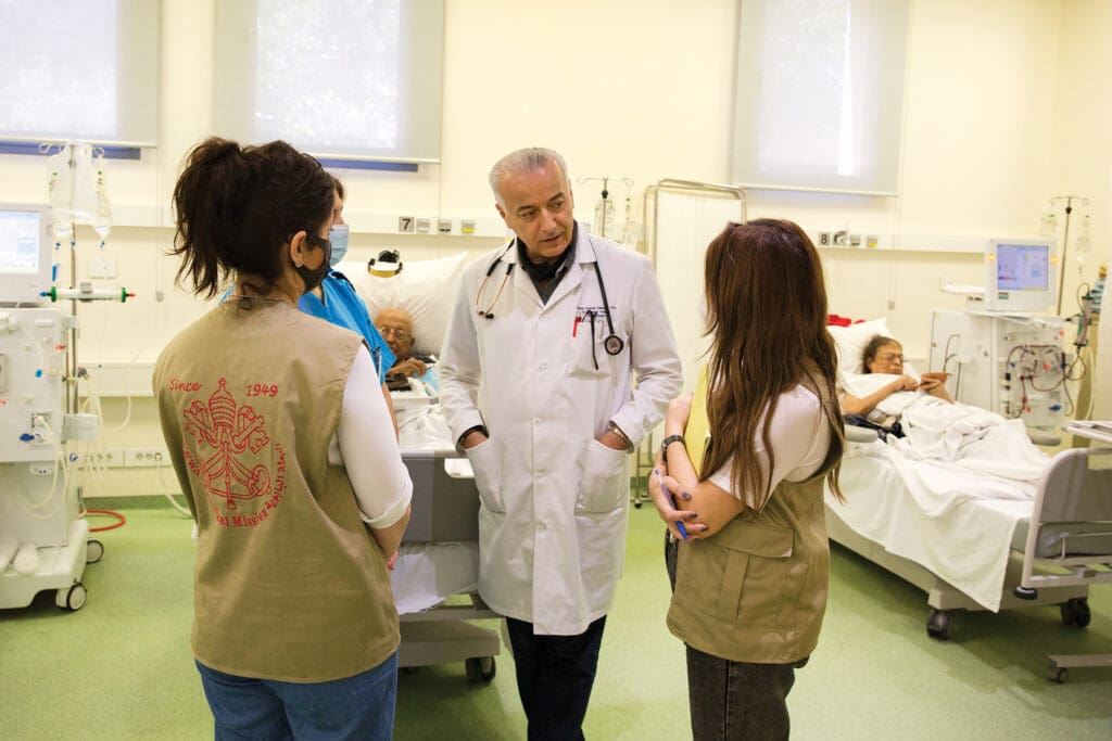 CNEWA-PM staff speaks with a doctor on the dialysis floor at Geitaoui Hospital in Beirut in June 2021