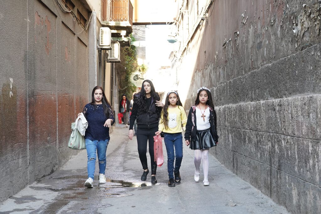 Girls walk on a street of Damascus