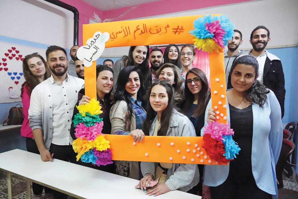 Lama Salloum (in blue shirt), program coordinator for the Family Support Project, poses with colleagues