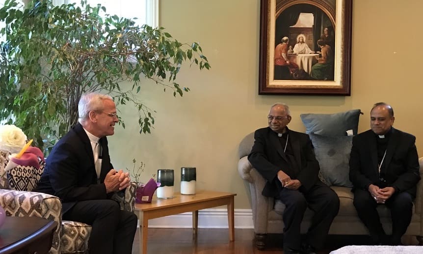 Monsignor Vaccari speaks with two bishops