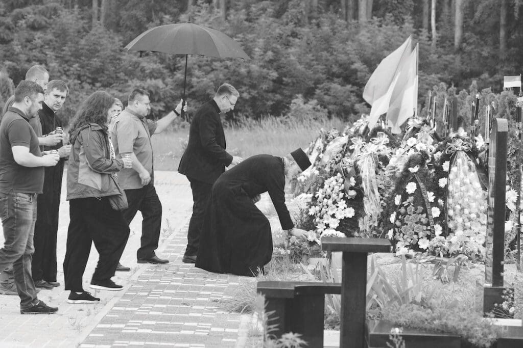 Archbishop Gudziak prays at a tomb in Ukraine