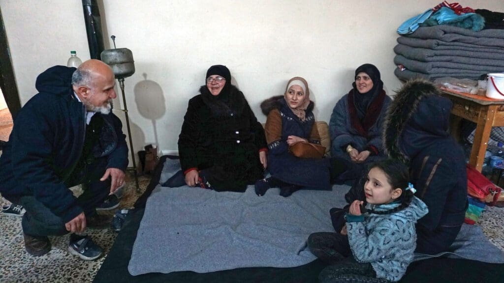 Michel Constantin, CNEWA’s regional director in Beirut, visits with a family in Aleppo.