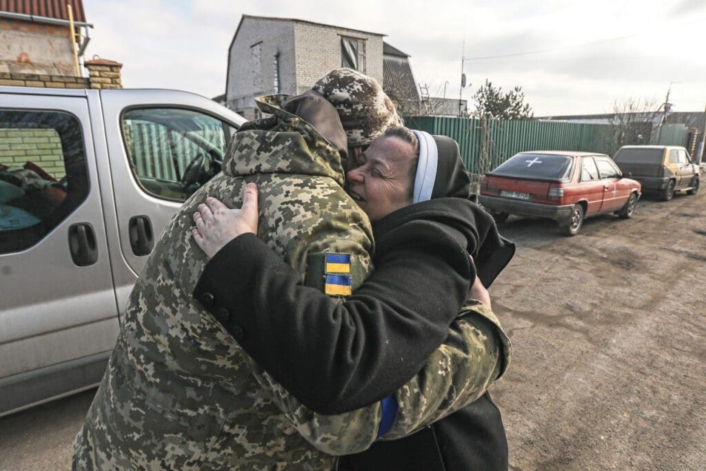 Sister Lucia Murashko in Zaporizhzhia, southern Ukraine, hugs a Ukrainian soldier who came from the front to pick up provisions.