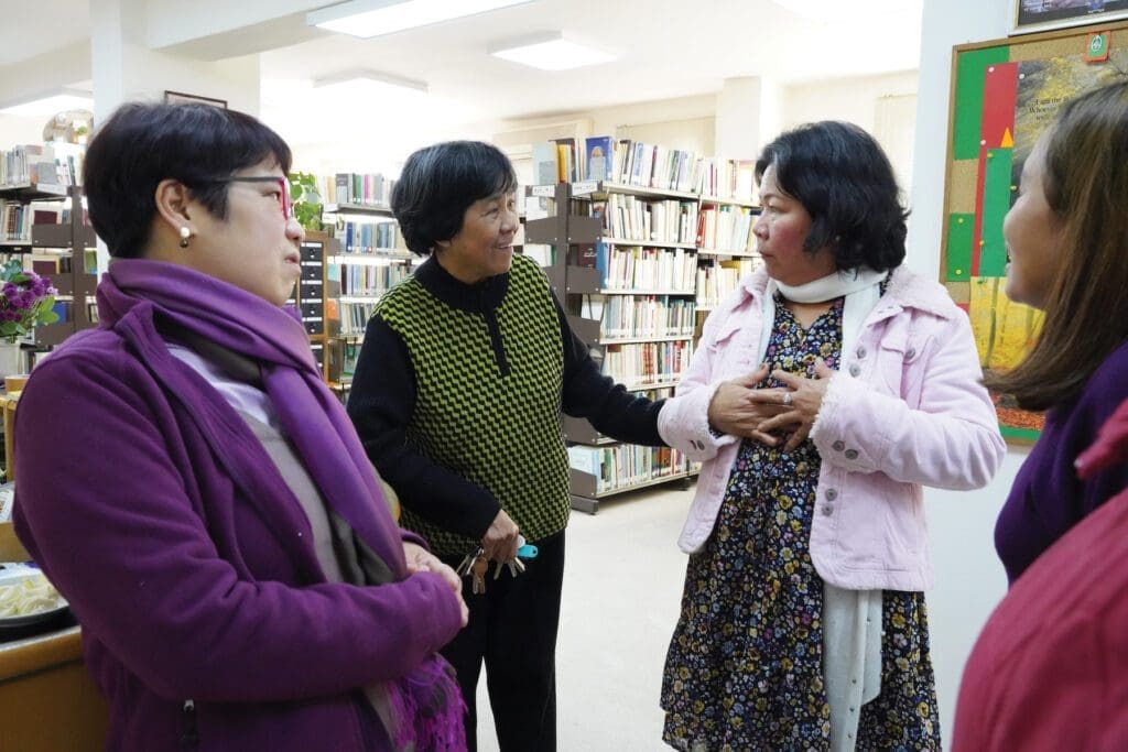 Elisa Estrada, a member of the Teresian Association, chats with two migrant workers from the Philippines.