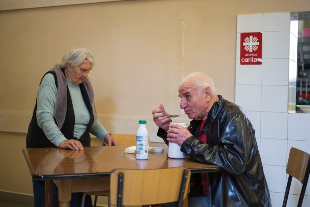 A man enjoys a warm meal at a food program in Tblisi, run by Caritas Georgia.