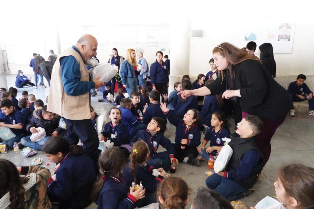 Regional director for CNEWA’s Beirut office, distributes packages to school children at a center of the Society of St. Vincent de Paul in Aleppo.