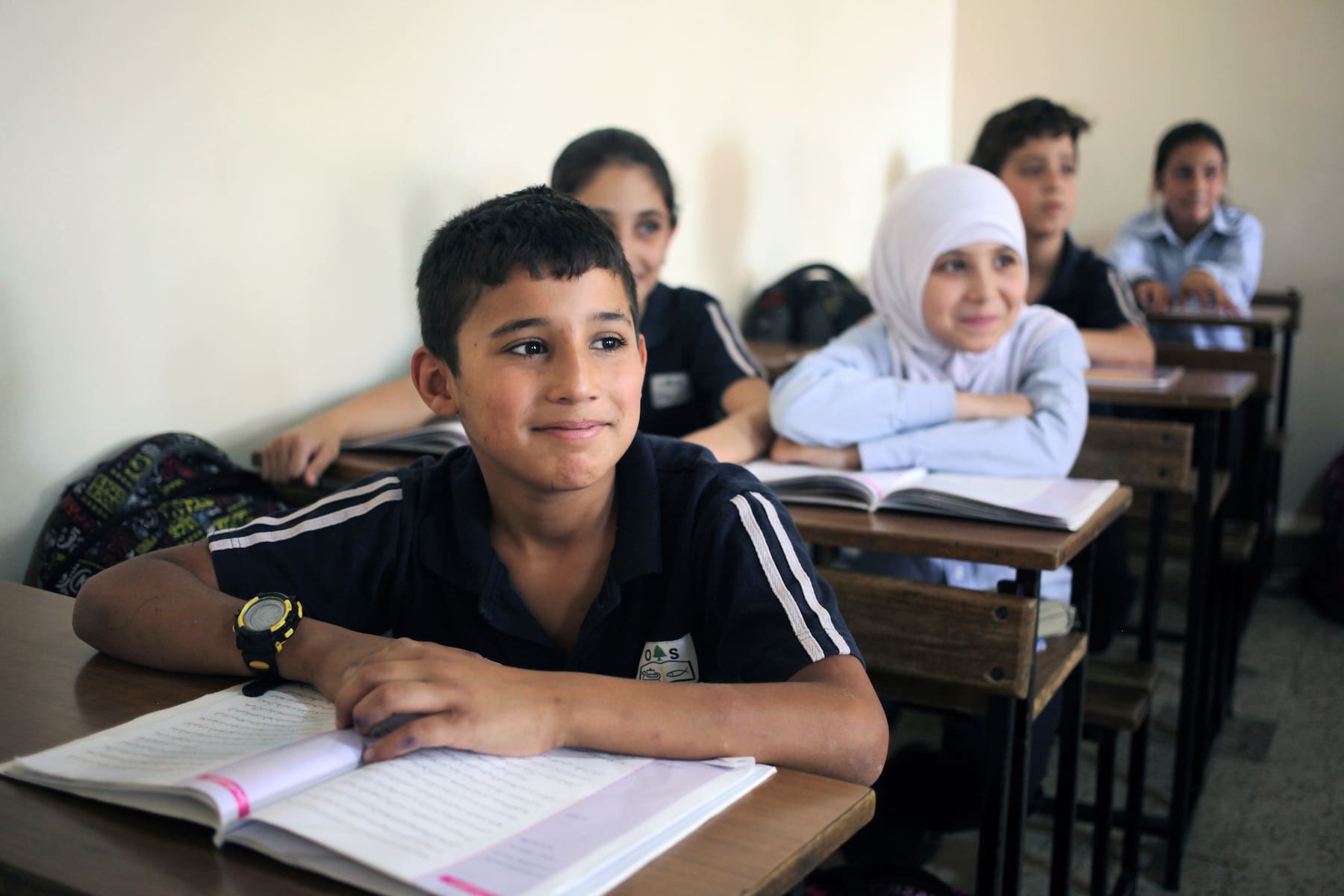 Young Lebanese students sitting at their desks.