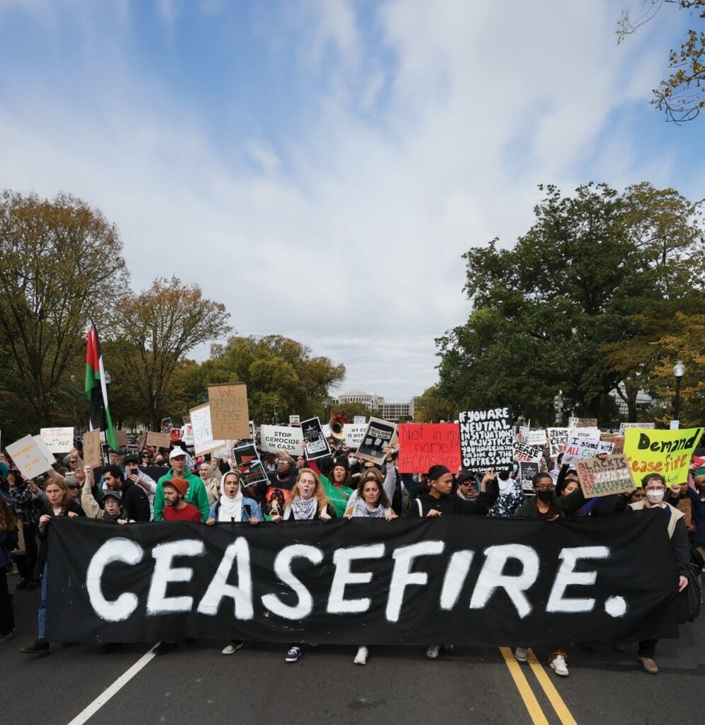 People march carrying a banner that reads "Ceasefire."