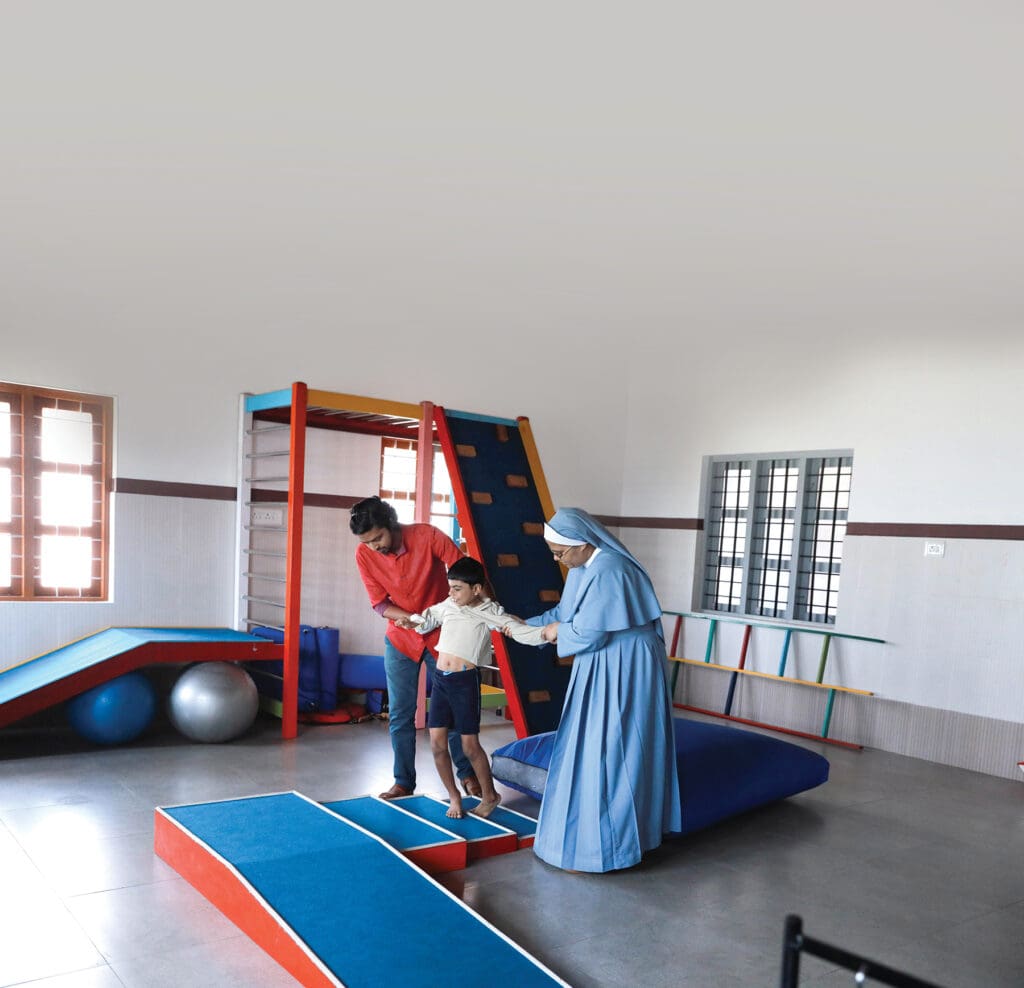Sister Jisna and physiotherapist Anjalo James assist a student, Joel Anto, during a physical therapy session. (photo: Sajeendran V.S.) A sister assists student during a physical therapy session