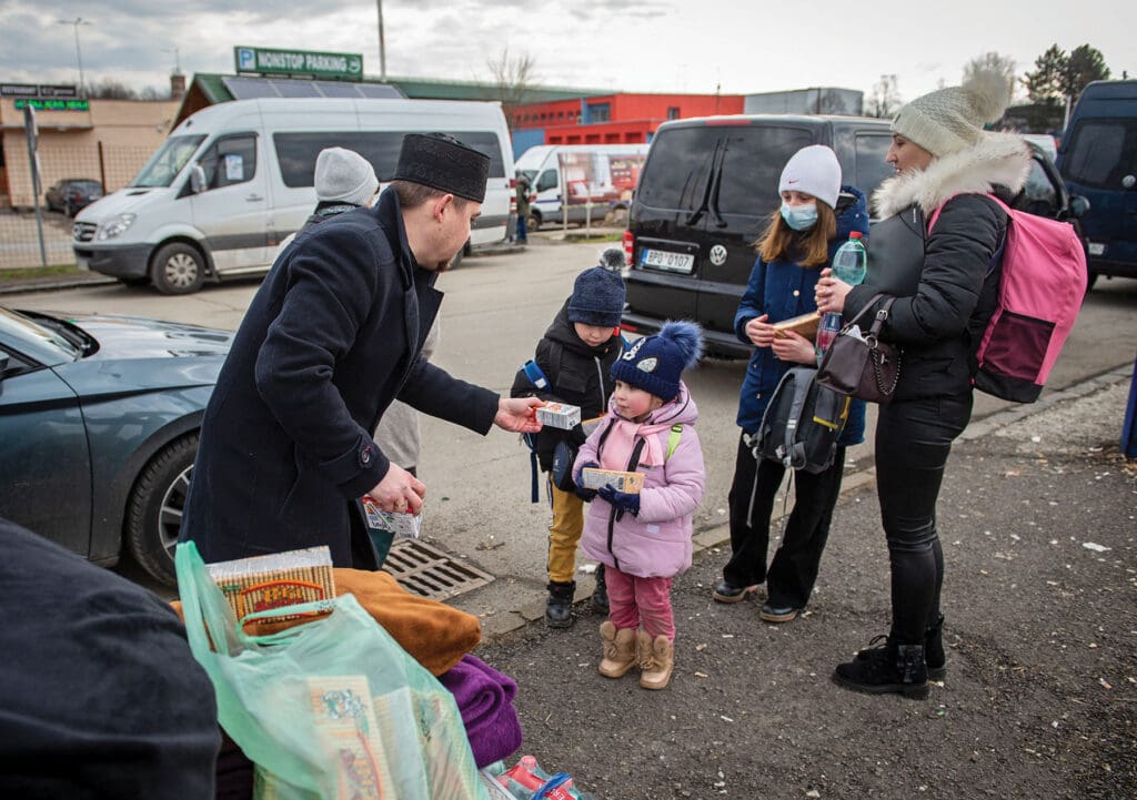 A Slovak priest gives drinks to Ukrainian refugees who crossed into eastern Slovakia on 25 February.