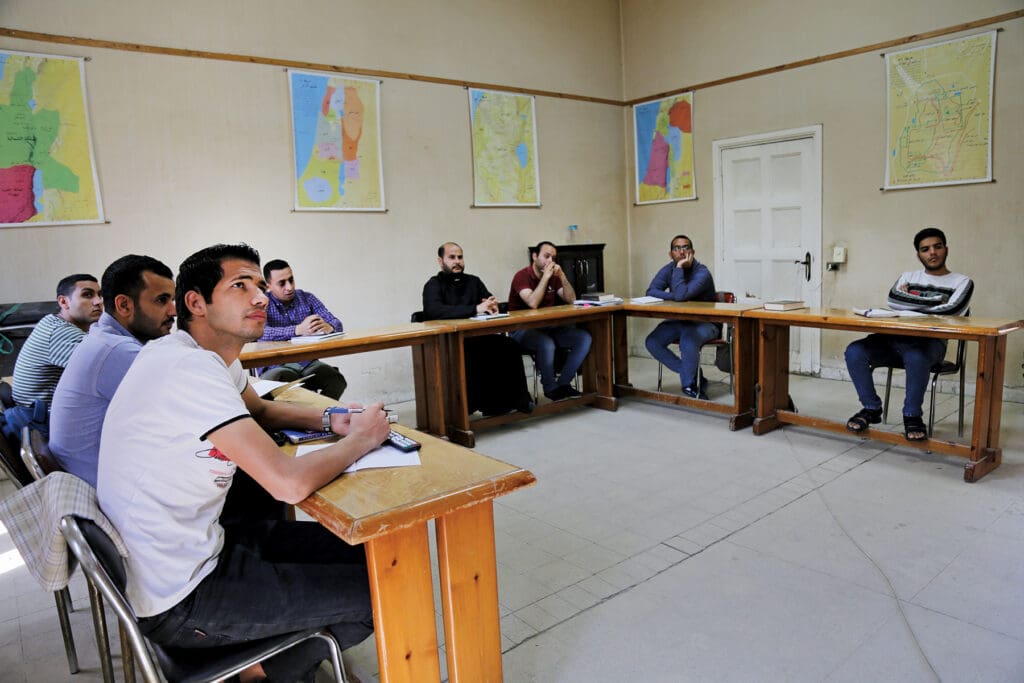 Seminarians listen to a presentation in a seminary classroom.